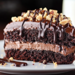 A close-up of a slice of Triple Chocolate Poke Cake. The cake is dark brown and moist-looking, with chocolate chips and a thick layer of chocolate ganache.