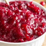 Close-up of bright red homemade cranberry sauce in a white bowl.